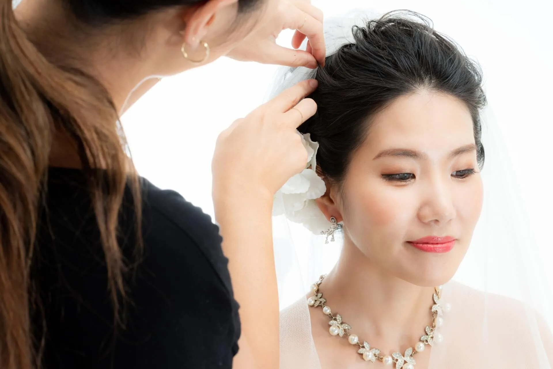 ウェディングアップヘアの仕上げをする女性